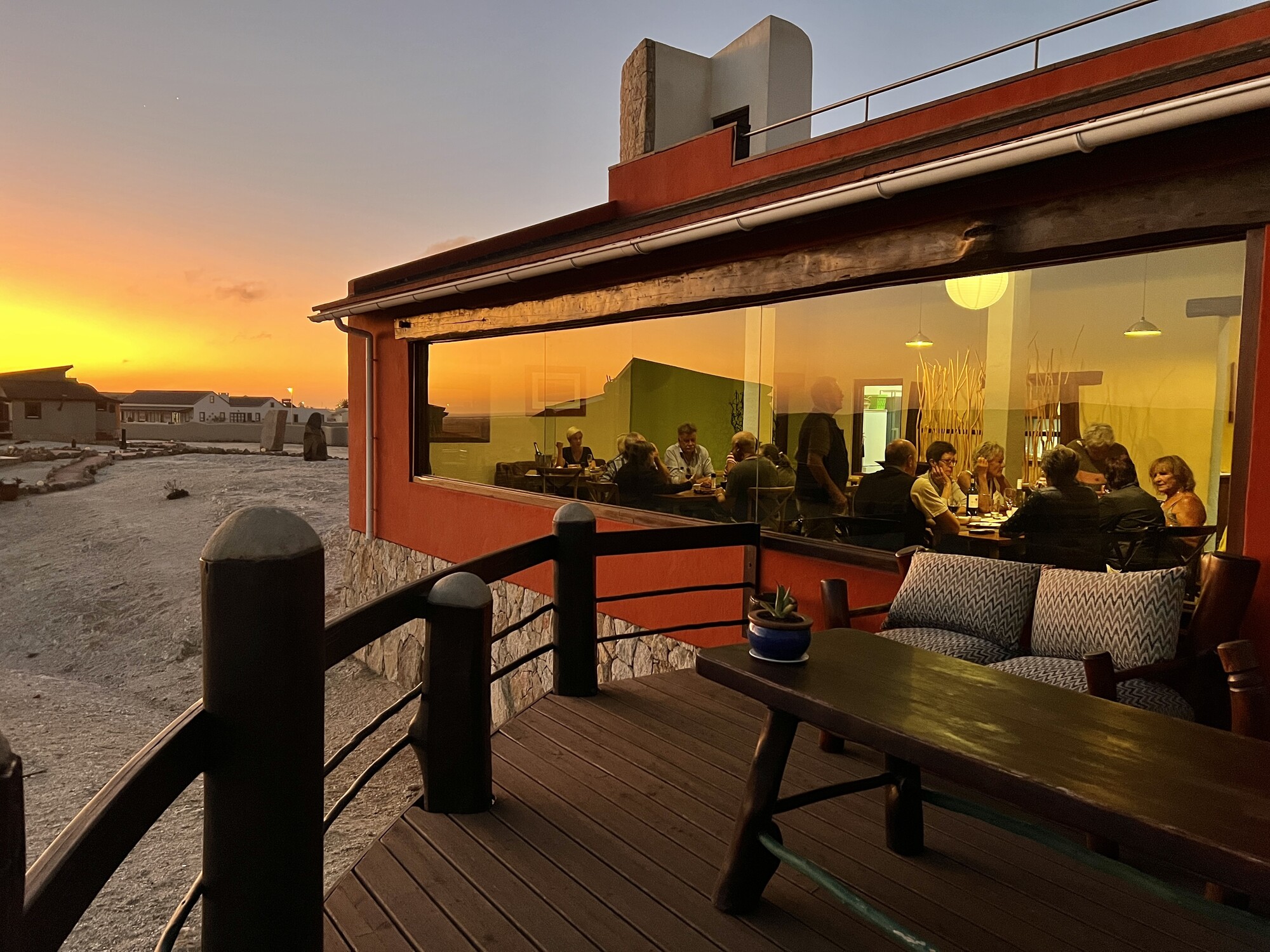 Guests dining at Desert Breeze as the sun sets over the dunes