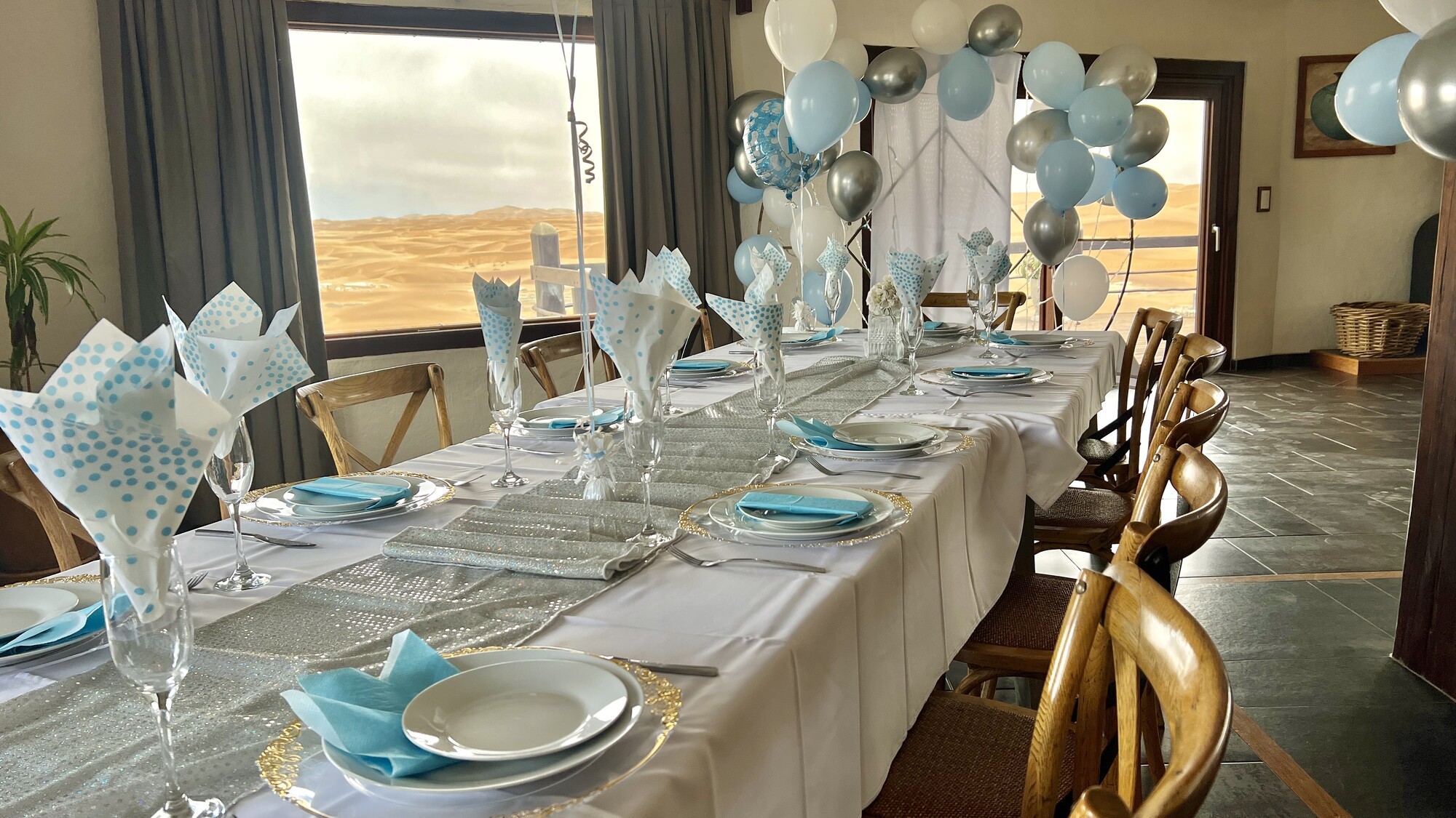 Celebration table decorated with blue and white balloons