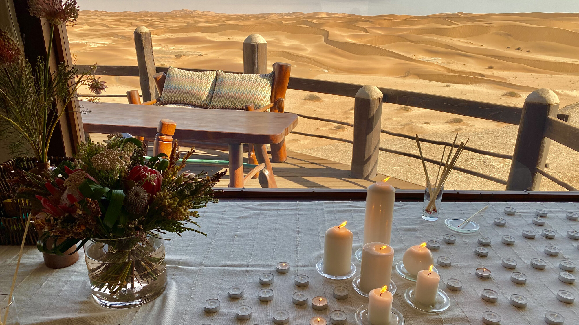 Candles and flowers arranged beside the dune-view terrace